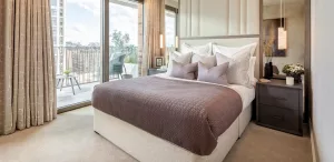 Property features a cozy bedroom with a large bed and plush pillows natural light streaming through floor-to-ceiling windows elegant decor and balcony access property