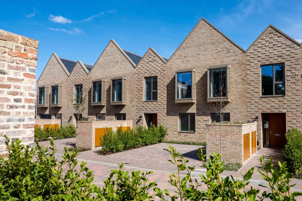 These are contemporary freehold townhouses with gable roofs and dormer windows, set in a landscaped courtyard.